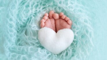 Baby's feet on a heart-shaped pillow