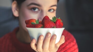 Woman holding a bowl of strawberries