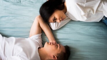 Couple lying on bed and looking at each other