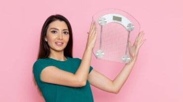 A woman holding weighing scale