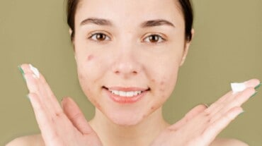 A woman applying moisturiser on her face