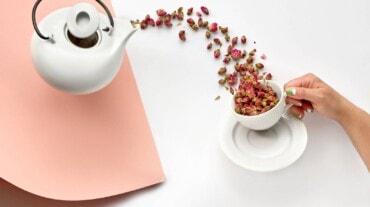 Rose petals flying from kettle to cup