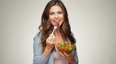 A woman eating summer fruit salad